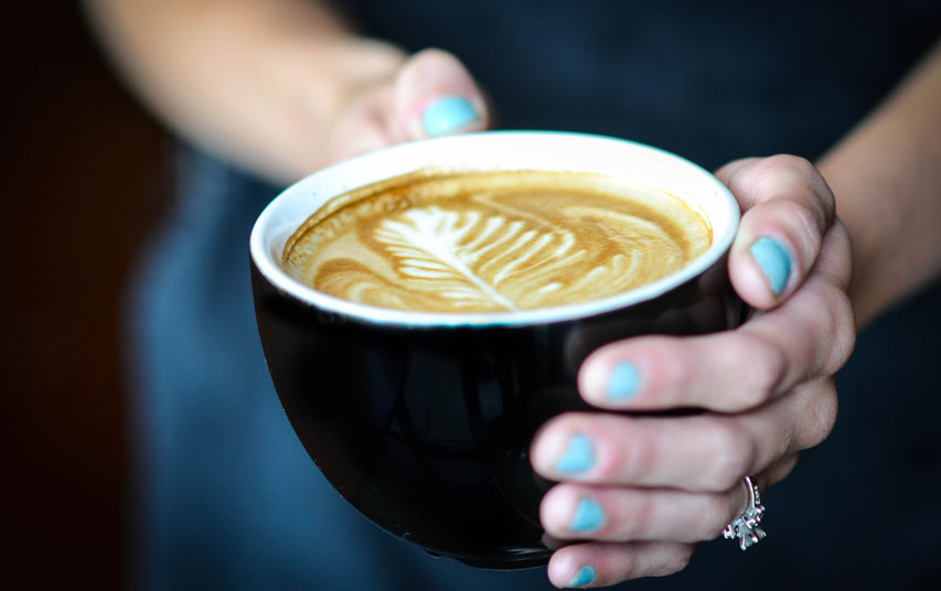 holding hot cup of coffee